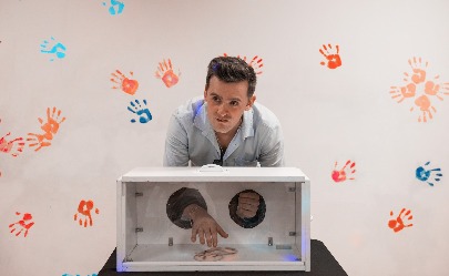 Un jóven mete sus manos dentro de una caja para tratar de identificar un objeto dentro de ella